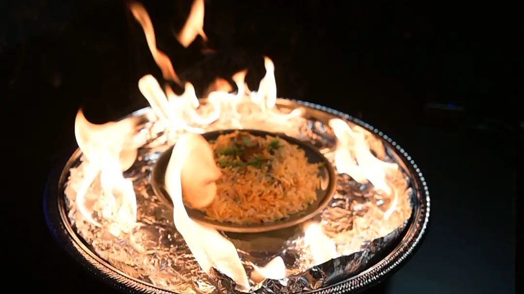 Biryani platter ringed in live flames at 47 Restaurant